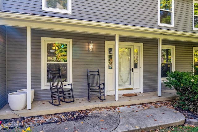 view of exterior entry featuring covered porch