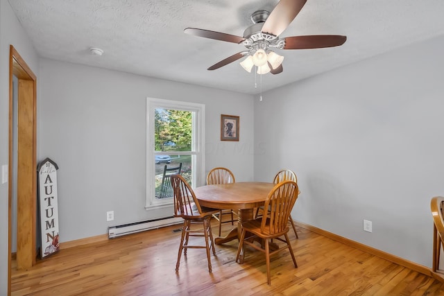 dining room with a textured ceiling, ceiling fan, baseboard heating, and light hardwood / wood-style flooring