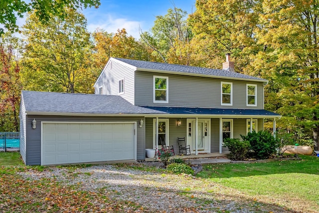 view of front of house featuring a front yard, a porch, and a garage