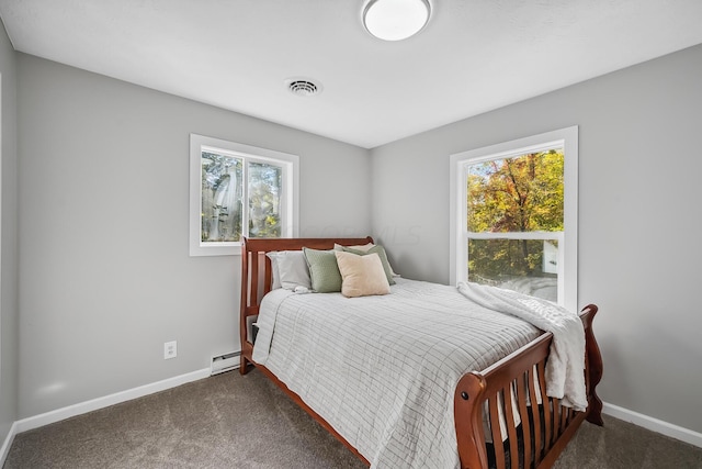 carpeted bedroom with multiple windows and a baseboard heating unit