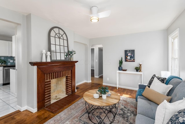 living room featuring a fireplace, ceiling fan, and hardwood / wood-style floors