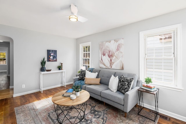 living room with ceiling fan and dark hardwood / wood-style flooring