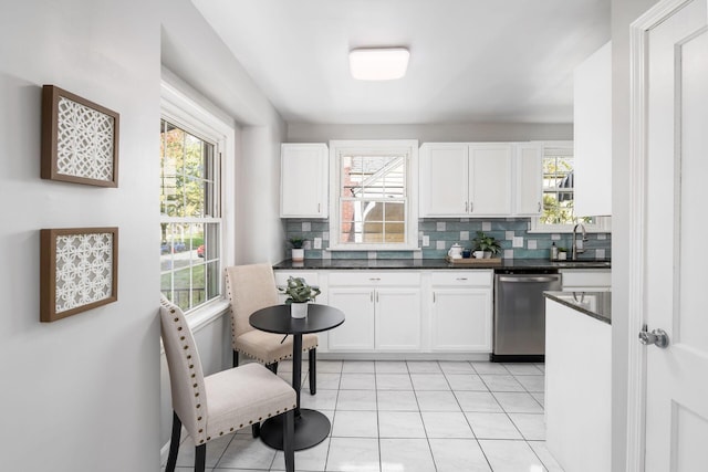 kitchen featuring dishwasher, white cabinets, sink, decorative backsplash, and light tile patterned floors