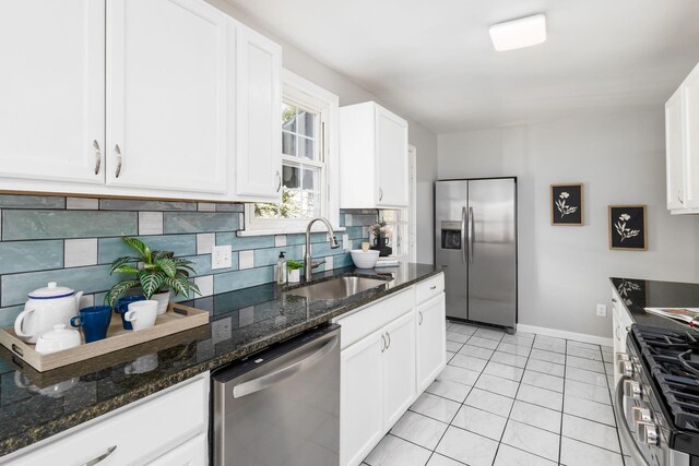 kitchen with backsplash, sink, white cabinets, and stainless steel appliances