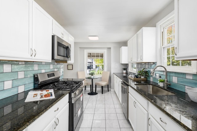 kitchen featuring decorative backsplash, stainless steel appliances, white cabinetry, and sink