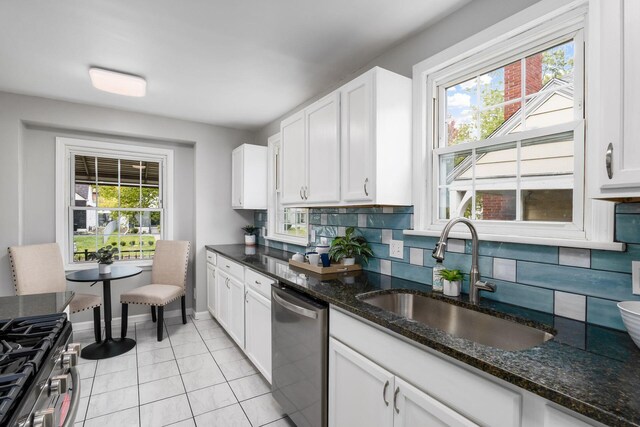 kitchen with white cabinetry, sink, stainless steel appliances, tasteful backsplash, and dark stone countertops