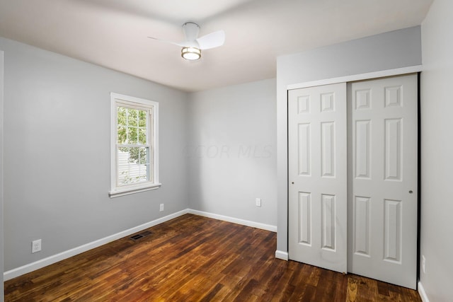 unfurnished bedroom featuring a closet, ceiling fan, and dark wood-type flooring