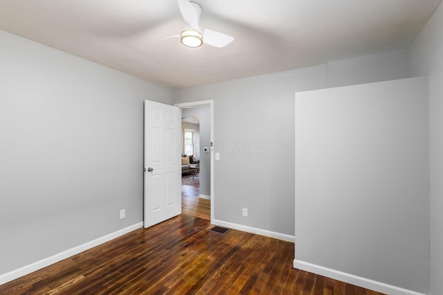 unfurnished room with ceiling fan and dark wood-type flooring