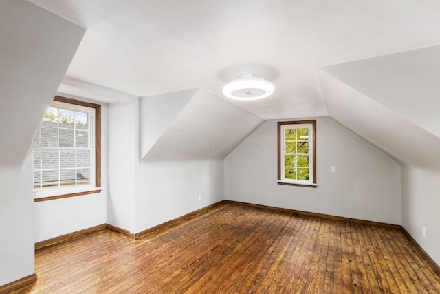 bonus room with light hardwood / wood-style floors, a healthy amount of sunlight, and vaulted ceiling