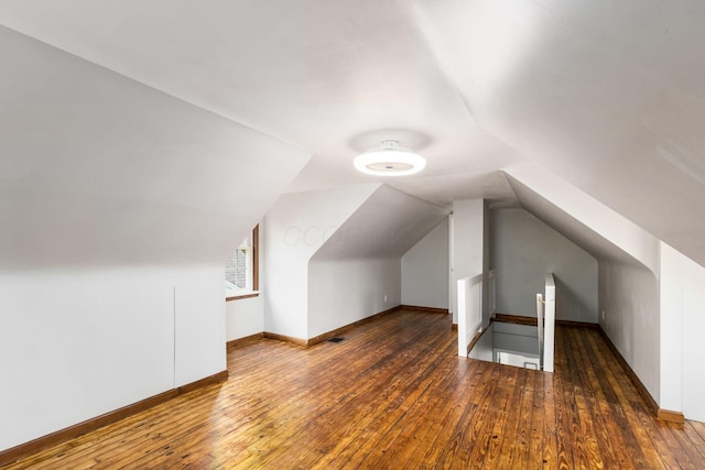 additional living space featuring dark hardwood / wood-style floors and vaulted ceiling