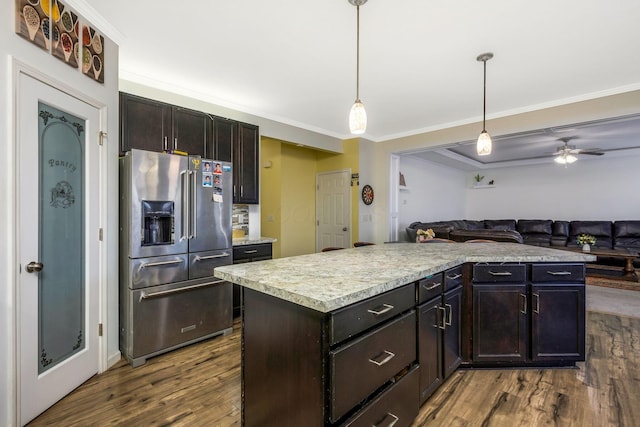 kitchen featuring dark hardwood / wood-style floors, crown molding, pendant lighting, high end fridge, and a kitchen island