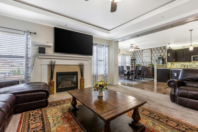 living room featuring ceiling fan, light hardwood / wood-style floors, and crown molding