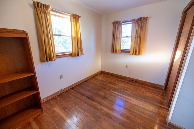 unfurnished bedroom with dark hardwood / wood-style flooring