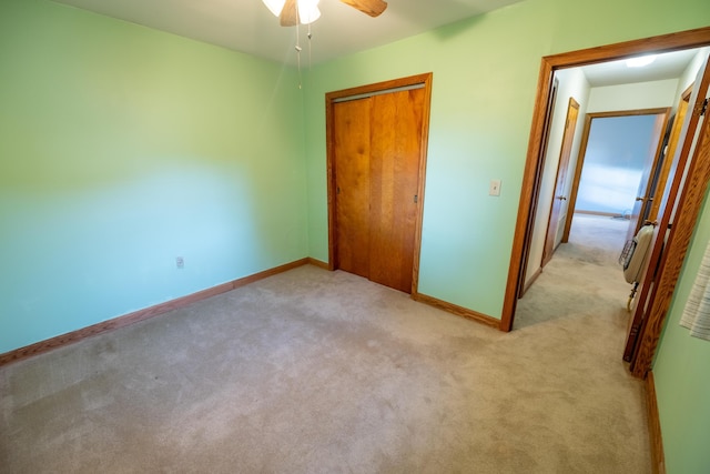 unfurnished bedroom with ceiling fan, light carpet, and a closet