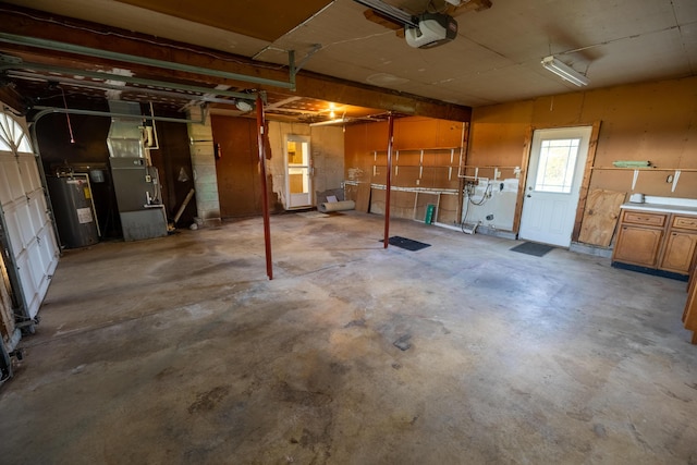 garage with heating unit, electric water heater, and a garage door opener