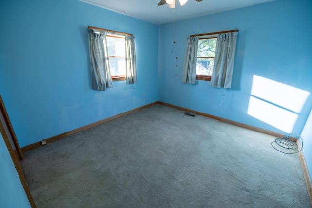 carpeted spare room with ceiling fan