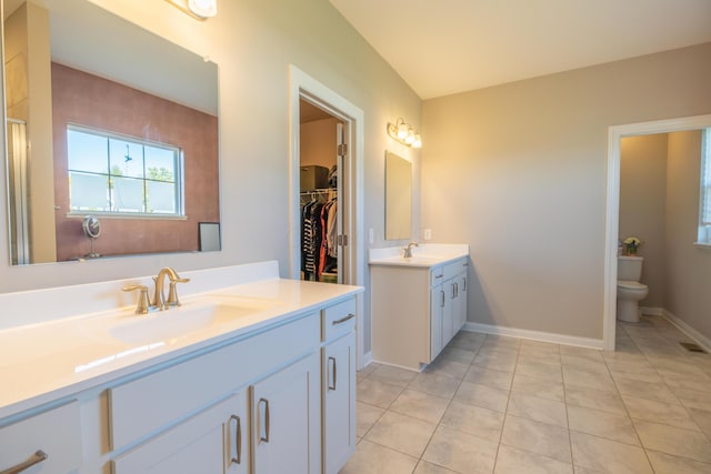 11996 Ficus Field Way, Plain City, OH 43064 - bathroom featuring two vanities, tile patterned floors, a walk in closet, and a shower with door