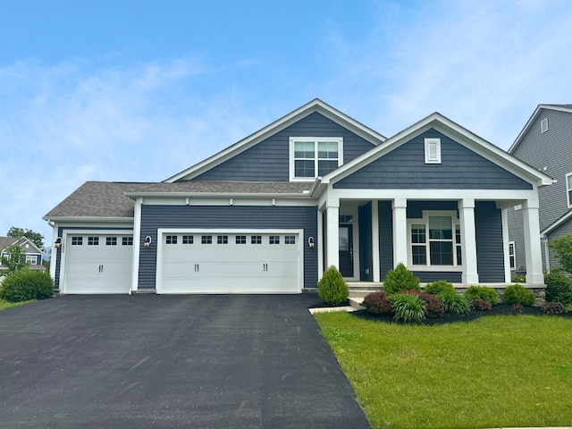 11996 Ficus Field Way, Plain City, OH 43064 - view of front of home featuring a front yard, driveway, a garage, and covered porch