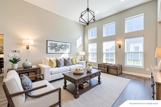 11996 Ficus Field Way, Plain City, OH 43064 - living area featuring dark wood-style flooring, recessed lighting, a towering ceiling, and a chandelier