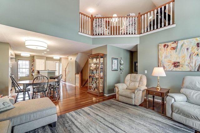 living room featuring hardwood / wood-style flooring and a towering ceiling