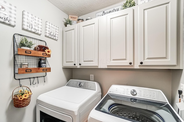 laundry area featuring washer and dryer, a textured ceiling, and cabinets