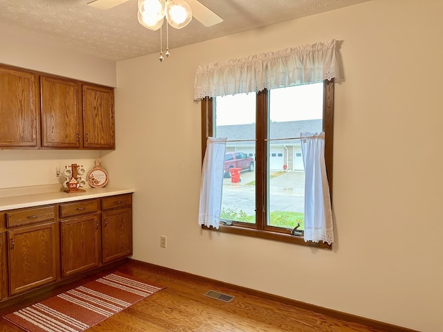 interior space featuring ceiling fan, hardwood / wood-style floors, and a textured ceiling