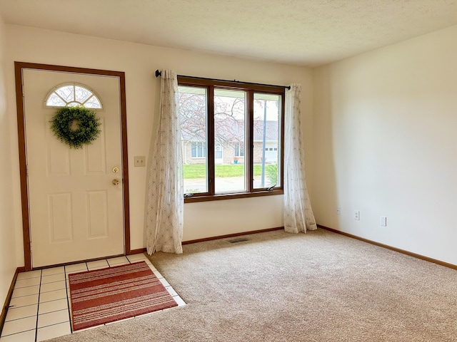 carpeted entrance foyer with a textured ceiling