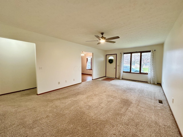 carpeted spare room featuring a textured ceiling and ceiling fan