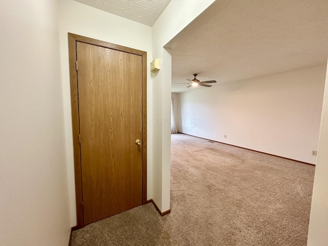 hallway with carpet floors and a textured ceiling