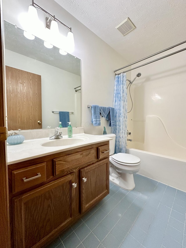 full bathroom featuring vanity, a textured ceiling, shower / tub combo with curtain, tile patterned flooring, and toilet