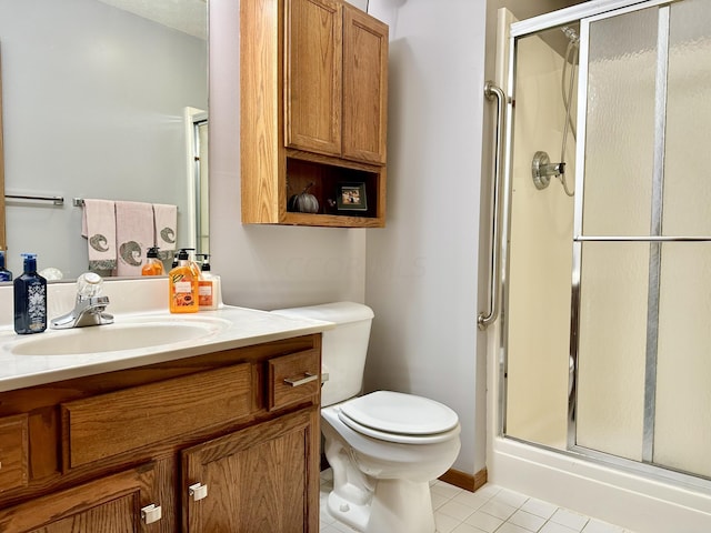 bathroom with tile patterned floors, vanity, an enclosed shower, and toilet