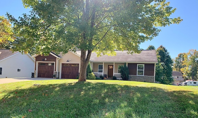 ranch-style home with covered porch, a garage, and a front yard