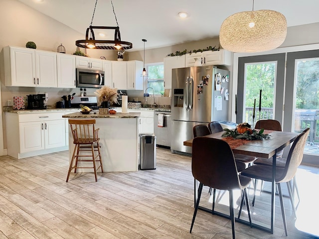 kitchen featuring plenty of natural light, decorative light fixtures, and appliances with stainless steel finishes