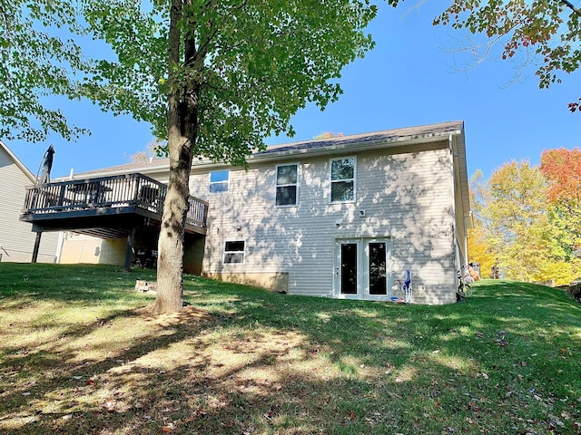 back of house featuring a lawn and a wooden deck