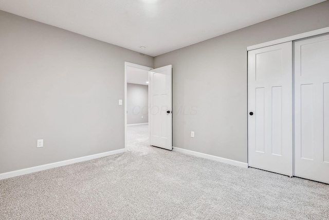 unfurnished bedroom with light carpet and a closet