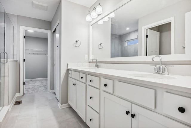 bathroom featuring tile patterned flooring, vanity, and walk in shower