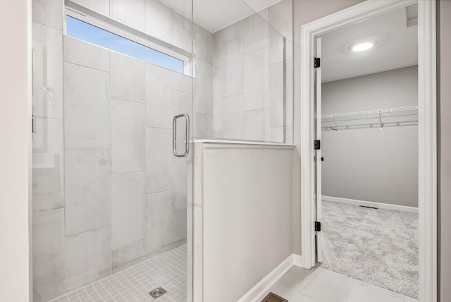 bathroom with tile patterned flooring and walk in shower