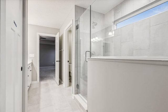 bathroom with a textured ceiling, vanity, toilet, and walk in shower