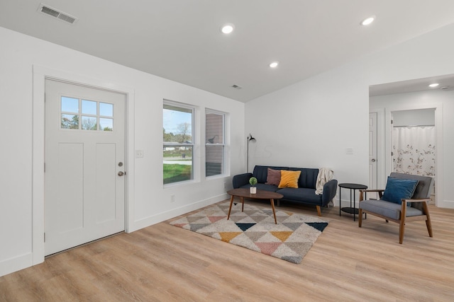 foyer entrance with light wood-type flooring and vaulted ceiling