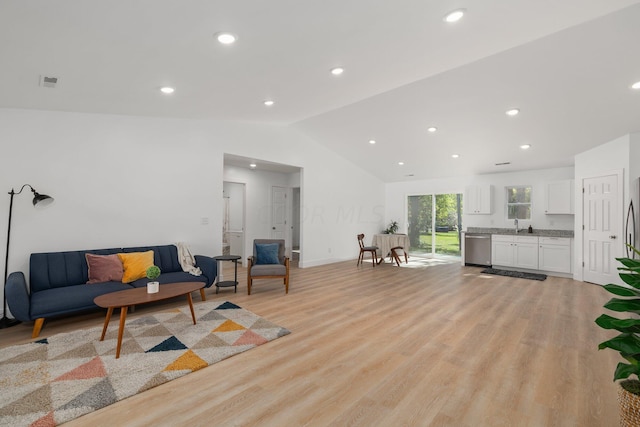 living room featuring lofted ceiling and light wood-type flooring