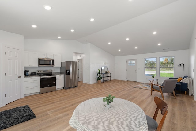 interior space with light hardwood / wood-style floors and lofted ceiling