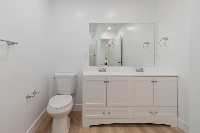 bathroom featuring toilet, vanity, and hardwood / wood-style flooring