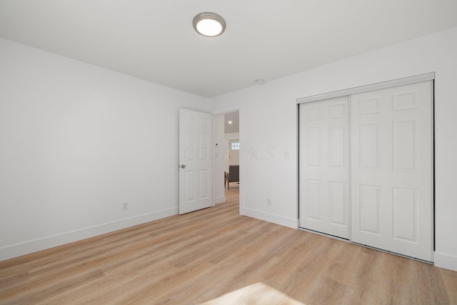 unfurnished bedroom featuring light wood-type flooring and a closet