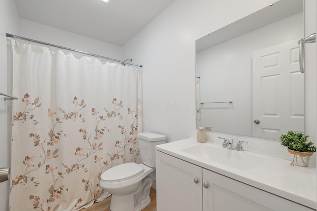 bathroom featuring a shower with curtain, vanity, and toilet