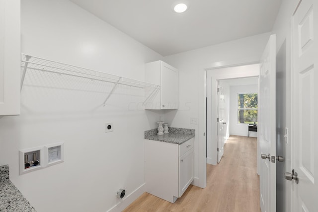 laundry room with washer hookup, hookup for an electric dryer, cabinets, and light hardwood / wood-style flooring