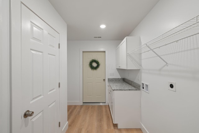 washroom with cabinets, light hardwood / wood-style flooring, washer hookup, and hookup for an electric dryer