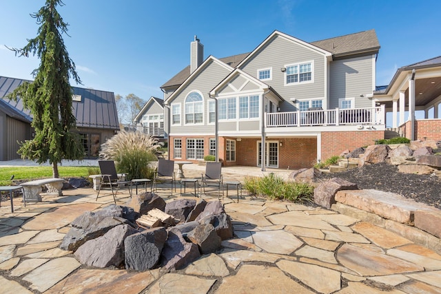 rear view of house featuring an outdoor fire pit and a patio area