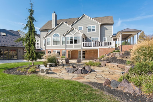 rear view of property featuring a yard, an outdoor fire pit, and a patio