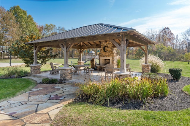 view of patio featuring a gazebo and an outdoor stone fireplace