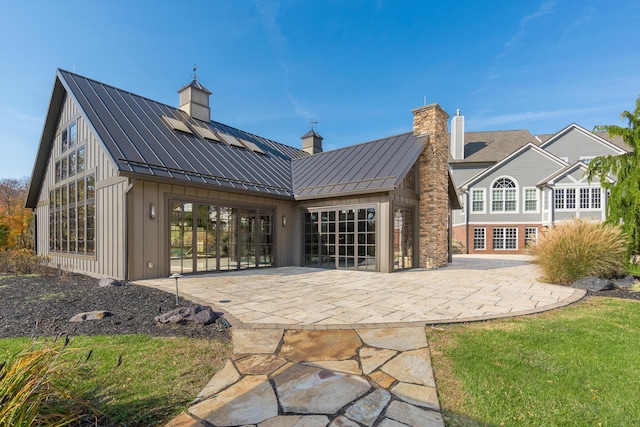 back of property with a patio and solar panels